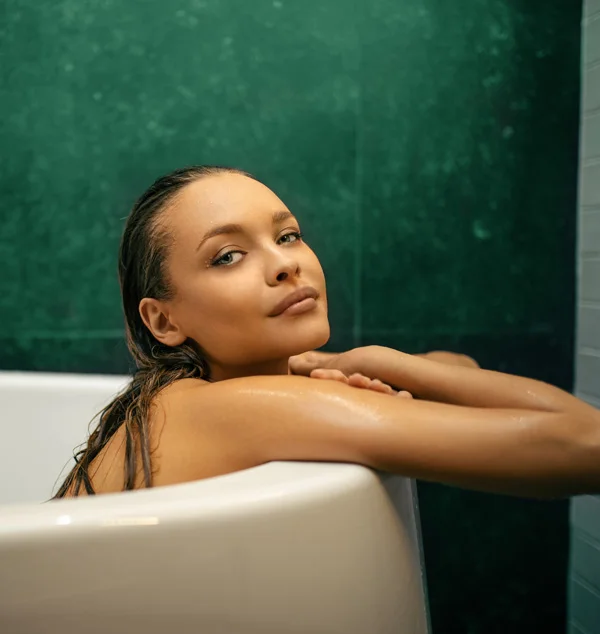 Woman leaning against the inside of a tub